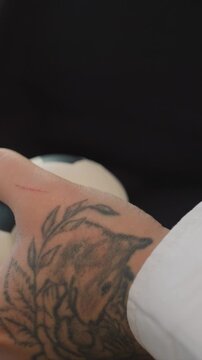 Close up of person hand with detailed tattoos. Focus remains steady highlighting intricate tattoo designs. Small red scratch is visible near one finger while minimal movement