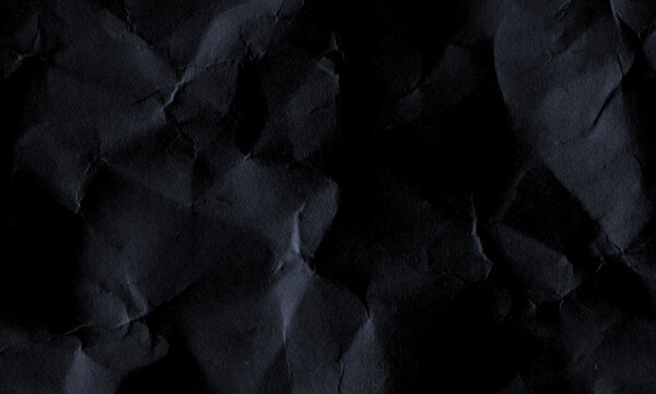 Dark black crumpled paper texture background with creased surface details and shadows Background