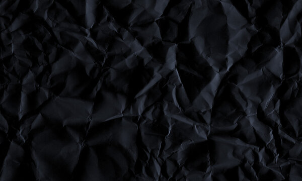 Dark black crumpled paper texture background with creased surface and dramatic shadows for design Background
