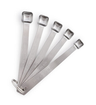 Five stainless steel measuring spoons of different sizes isolated on a white