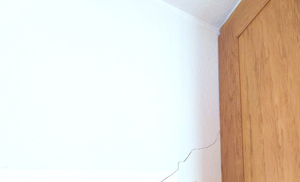 drywall (plasterboard, sheetrock) crack by kitchen cabinetry wall due to ground subsidence or movement