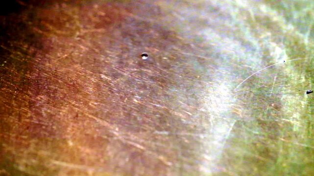 Macro view of scratched brass metal surface texture with concentric circular grooves background