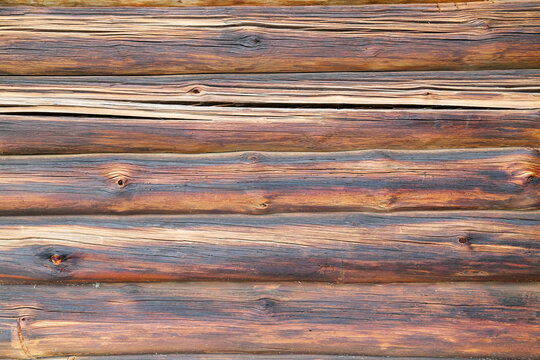 The background of the wall is made of a brown wooden log house. Backgrounds, textures, design.