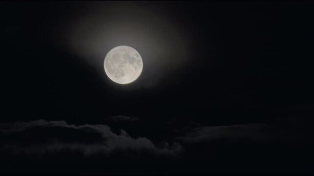 Close-up of a glowing full moon in the dark night