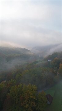 A drone camera flies over autumn mountains early in the morning at dawn. Vertical video