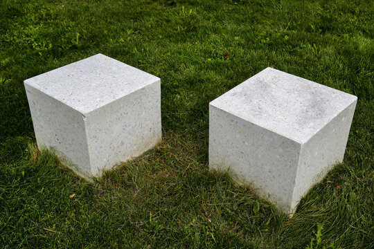 Two marble cubes on a background of green grass on a clear sunny day. Playgrounds, toys, sports.