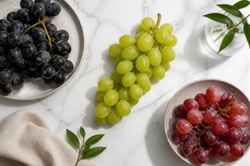 Fototapeta premium Mixed grapes arranged on marble countertop with plates