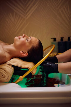 Serene woman relaxing during luxury hair spa therapy.