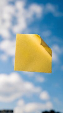 Yellow sticky note floating against blue sky