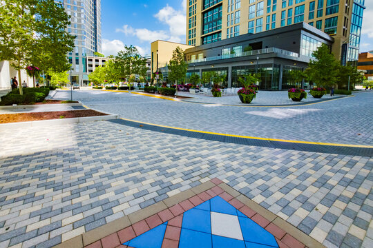 Spacious Reston plaza features patterned paving, outdoor furniture, and modern architecture.