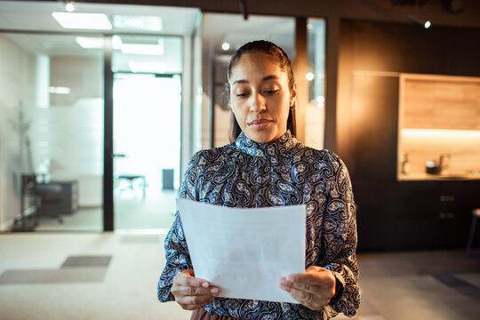 Young professional woman reviewing document in modern office
