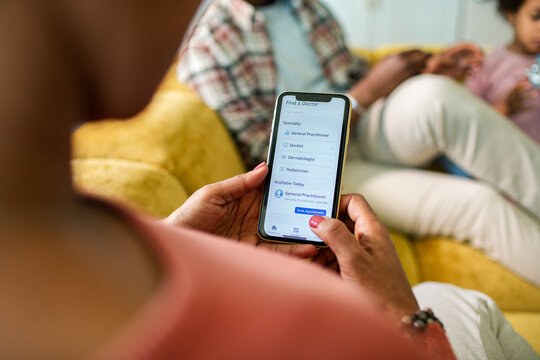 Parent booking a doctor appointment on smartphone at home