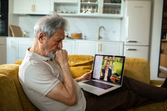 Senior man watching telehealth consultation at home