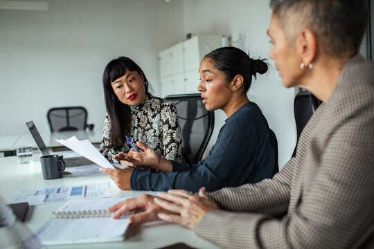 Businesswomen collaborating in modern office meeting