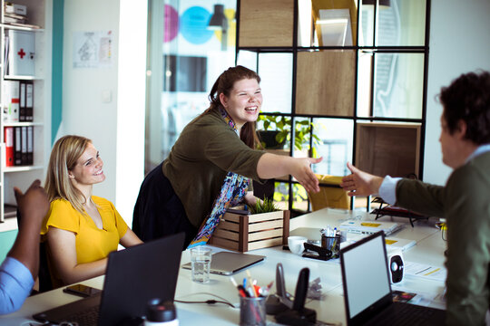 Coworkers greeting with handshake in modern office