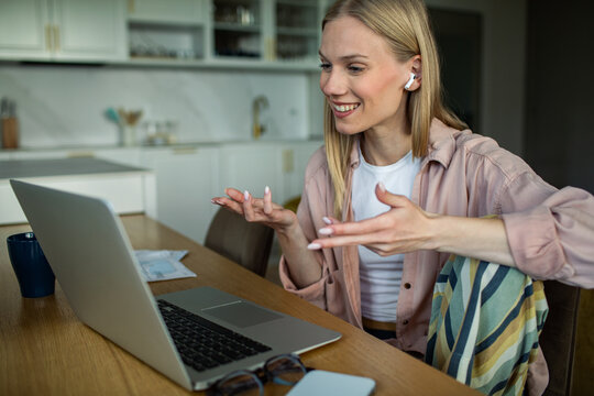 Smiling woman on video call in home kitchen