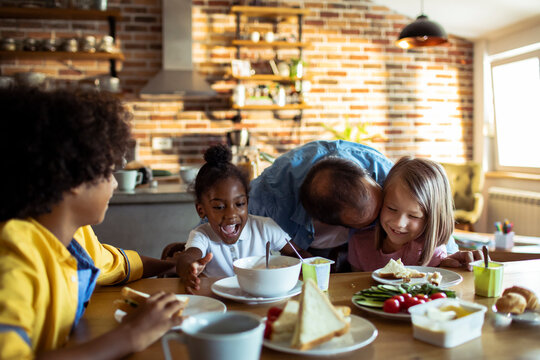 Father and children enjoying breakfast at home kitchen