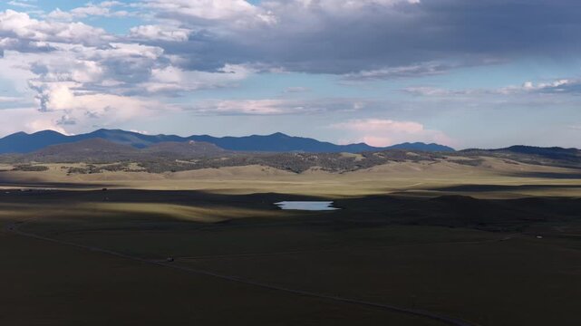 Aerial of vast Colorado prairie and Tenmile mountain range near Como in summer with dark clouds