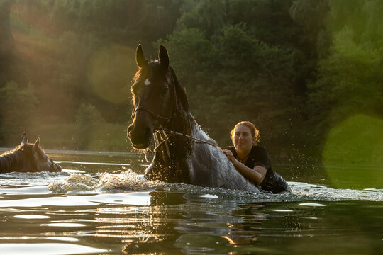 Reiterin badet mit Pferd
