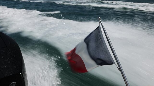 French Flag Flying from the Stern of a Moving Motorboat at Sea