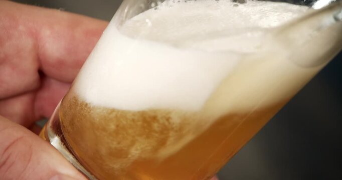 Beer being filled into glass close up in industrial factory brewery