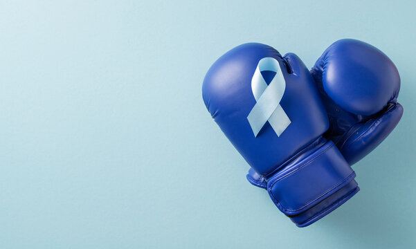 Blue boxing glove with ribbon symbolizing Men's health and Blue Ribbon Awareness Month for prostate cancer prevention and support on banner pastel background