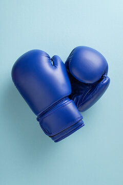Blue boxing gloves symbolizing men's health and blue ribbon awareness month support and strength on vertical light background