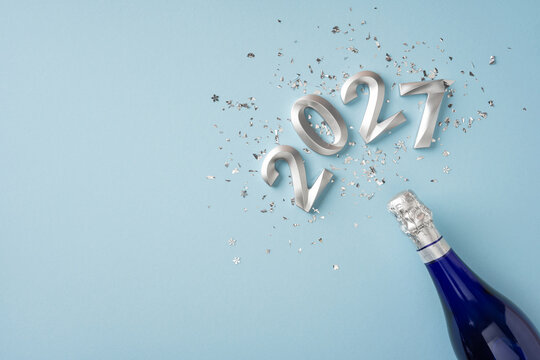 Happy New Year 2027 celebration with champagne bottle, silver confetti and winter holiday vibes