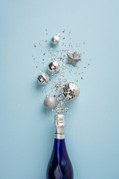 Happy New Year 2027 celebration with champagne bottle and silver ornaments on blue vertical background