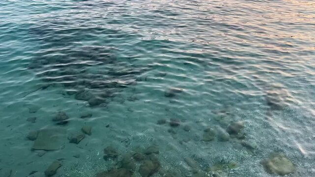 Crystal clear turquoise Adriatic Sea water with visible seabed and stones, close up. Clear Mediterranean Sea water with visible stones and underwater seabed