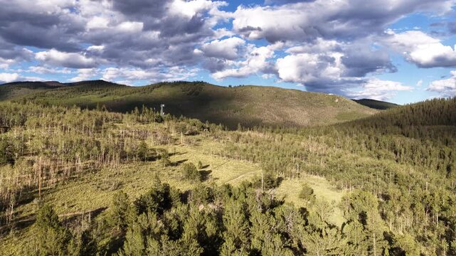 Sunny aerial of temperate forest landscape near Kenosha Pass Colorado with rolling hills covered by coniferous trees