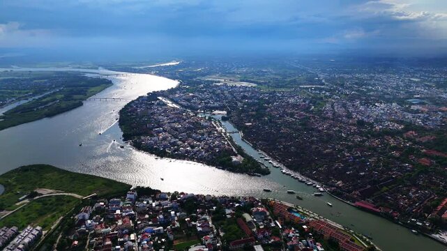 aerial drone view of Hoi An Ancient Town and Thu Bon River waterway under dramatic skies in Quang Nam