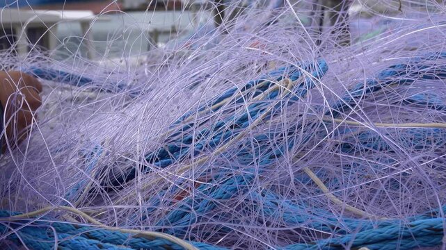 People prepare fishing nets on a boat by the sea