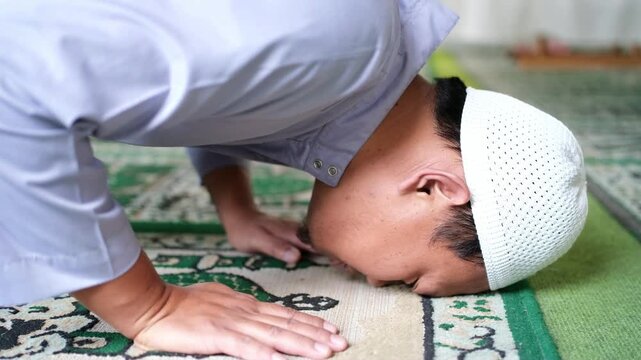 Close-up of the head position during prostration in prayer. Islamic worship. A movement within the prayer. A Muslim man performing prayer.
