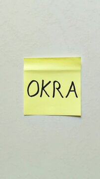 Yellow sticky note with handwritten okra word isolated on white background