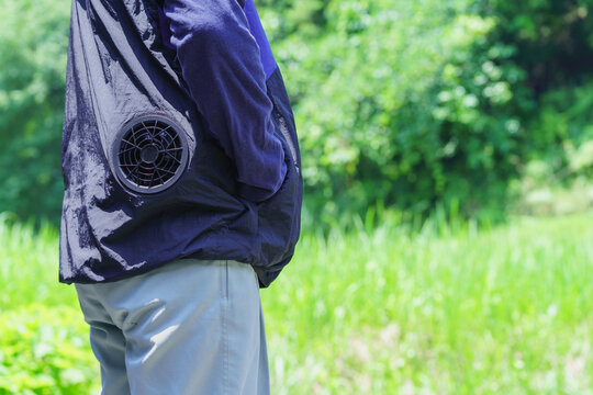 熱中症対策でファン付きウェアを着る男性