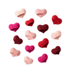 Fototapeta premium Scattered pink and red folded felt hearts on a transparent studio background with soft shadows and textured fabric details. Romantic valentine day atmosphere