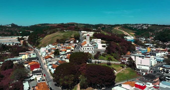 4K aerial drone view of a historic Catholic church surrounded by traditional houses and urban architecture in Santa Isabel, S&atilde;o Paulo, Brazil.