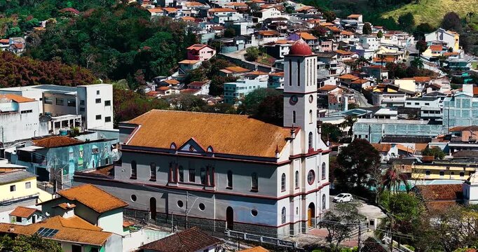 4K aerial drone view of a historic Catholic church surrounded by traditional houses and urban architecture in Santa Isabel, S&atilde;o Paulo, Brazil.
