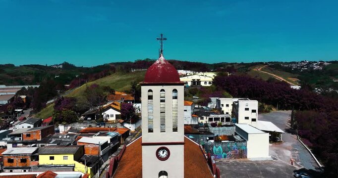 4K aerial drone view of a historic Catholic church surrounded by traditional houses and urban architecture in Santa Isabel, S&atilde;o Paulo, Brazil.