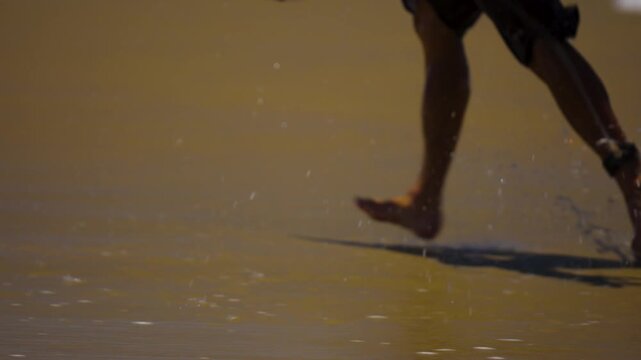 close up of surfers feet as they run on the sand