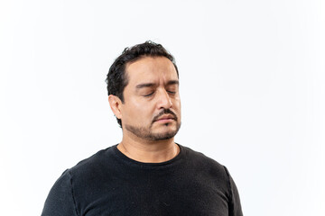 Fototapeta premium Latino man meditating with eyes closed in studio