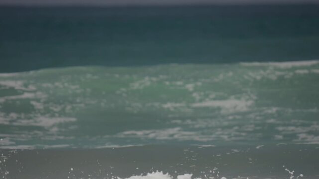 Light blue green waves breaking in the ocean