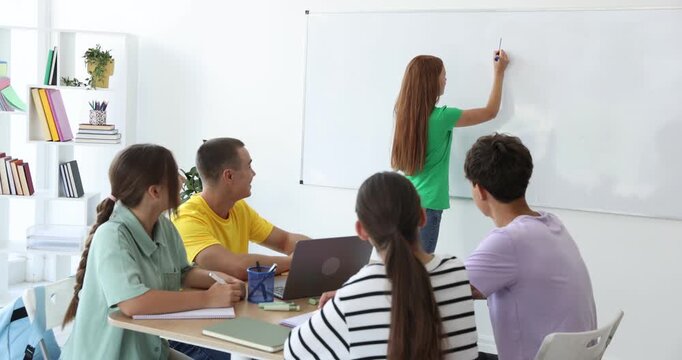 Teenage girl doing presentation for her classmates in school