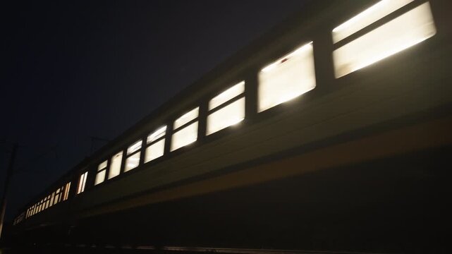 Night Passenger Train Approaching with Bright Headlights | Illuminated Windows Passing By in Darkness | Low Angle Railway Motion Shot