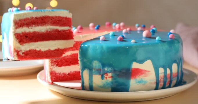 Baby gender reveal party. Taking slice of cake with pink layers and putting it onto plate at table, closeup