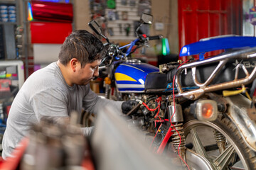 Obraz premium Mechanic repairing motorcycle in a workshop