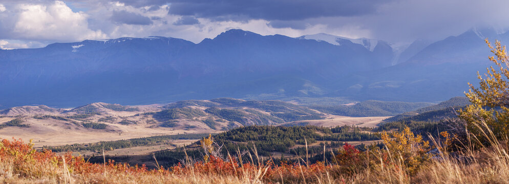 Mountain autumn landscape, contrasting evening light, cloudy sky