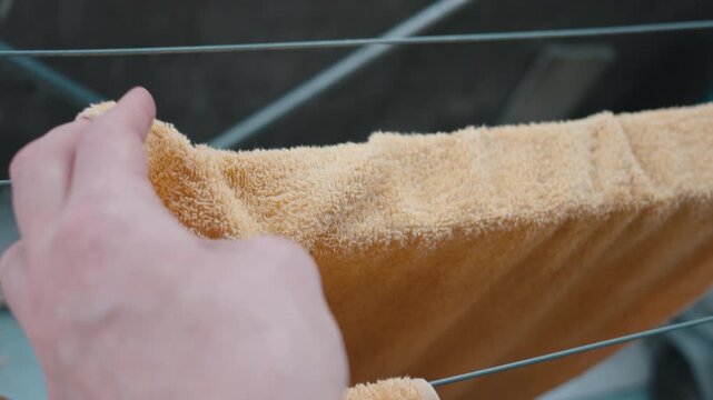 Hands Hanging Orange Towel on Drying Rack Close-Up | Folding Fresh Terry Cloth Fabric | Everyday Laundry Routine at Home
