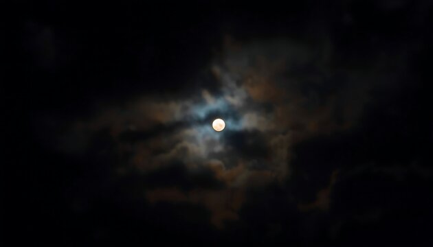A full moon is partially obscured by dramatic, swirling dark clouds against a black night sky.